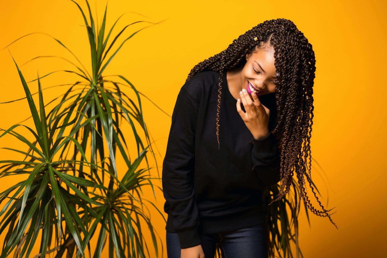 Model wearing long twisted braids in seamless protective style.