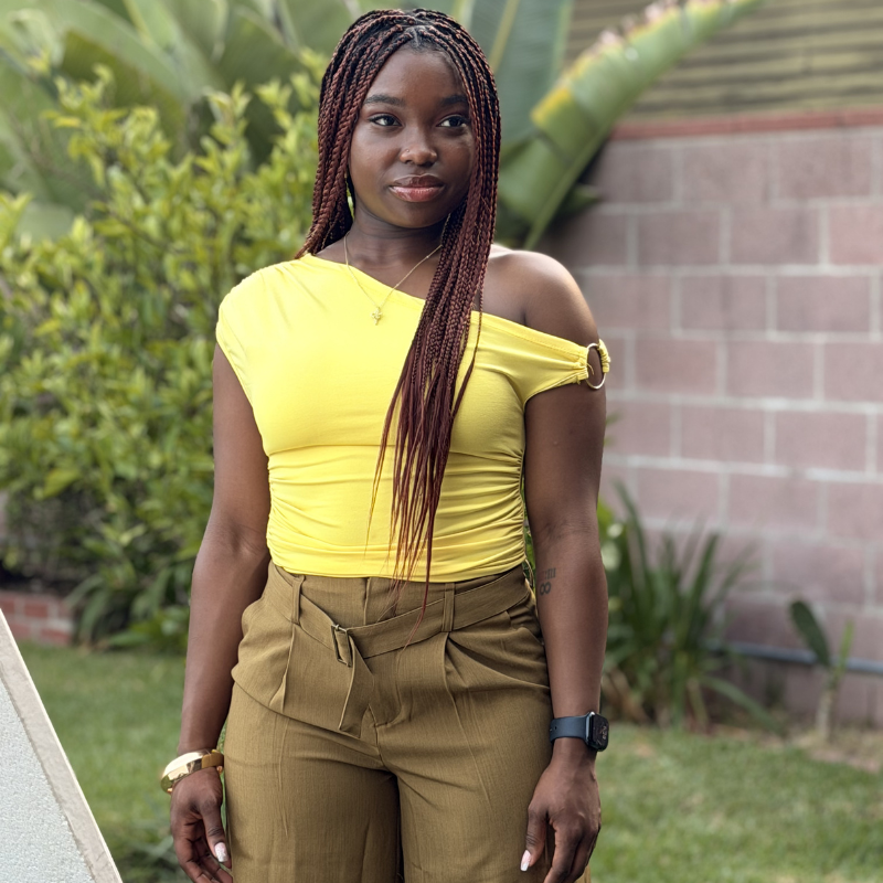 Woman outdoors wearing long Blhair™ Berry Noir braids with rich burgundy-toned protective hairstyle.