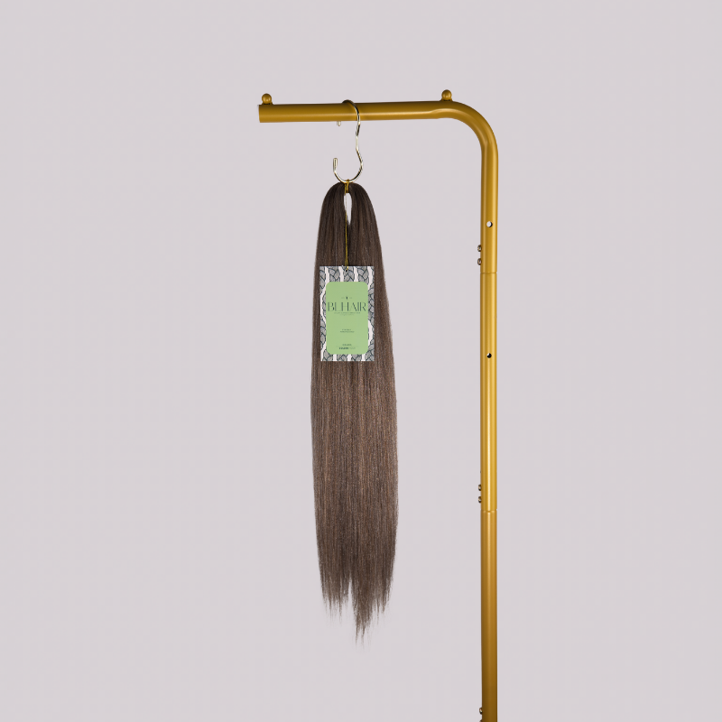 Blhair™ Golden Hour braid hair bundle hanging on gold stand against neutral background.