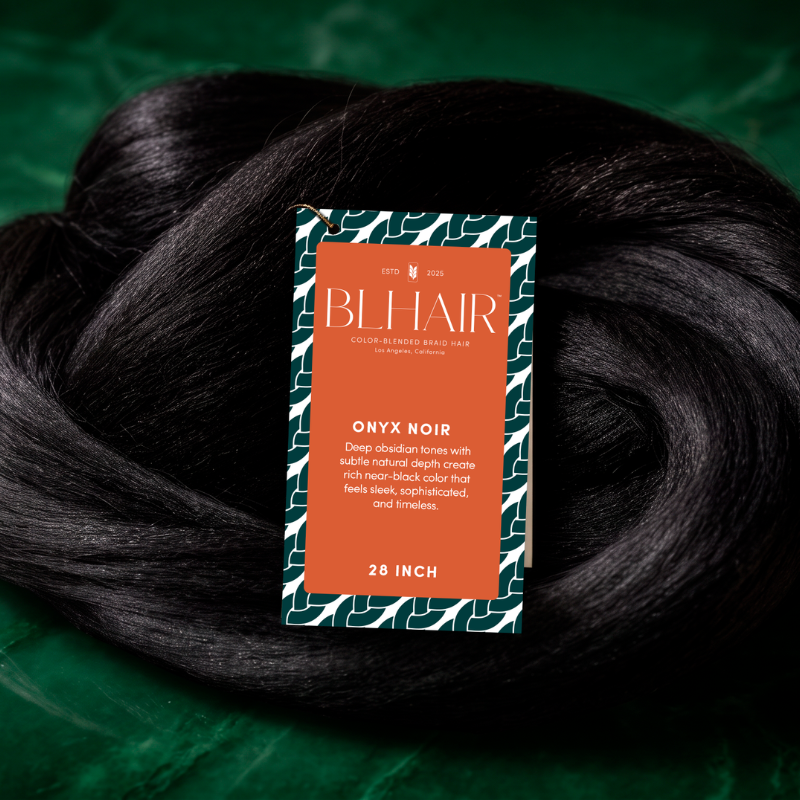 Blhair™ Onyx Noir near-black braid hair displayed on deep green satin with its product tag.
