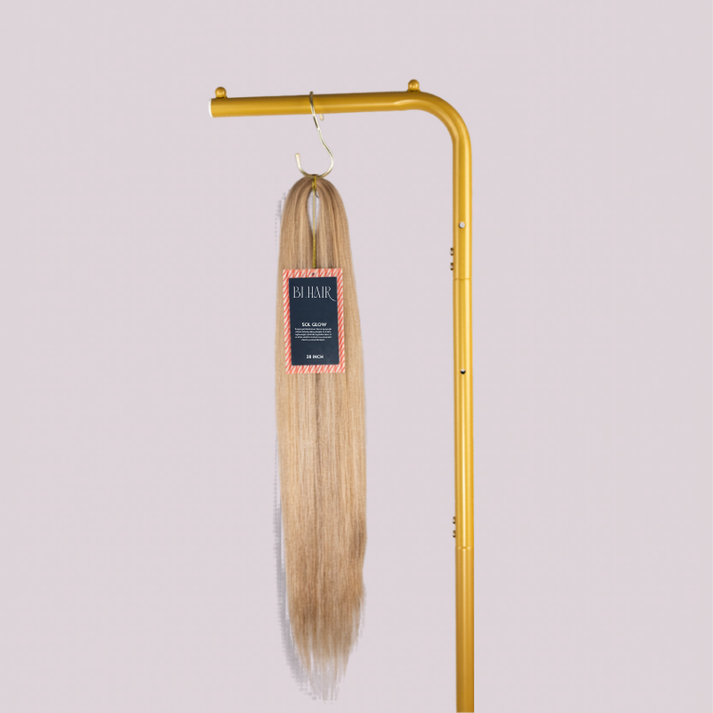 Blhair™ Sol Glow braid hair bundle hanging on gold display stand against neutral background.